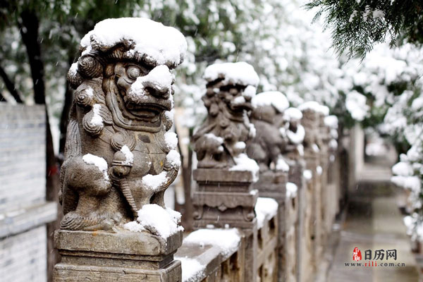 厚厚的积雪压在狮子雕塑上