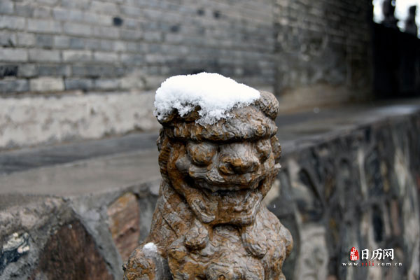 雕塑狮子头上压着厚厚的积雪