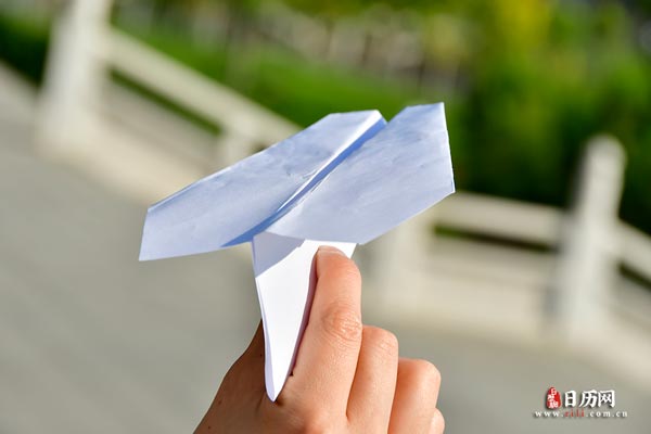 手拿纸飞机飞向蓝天