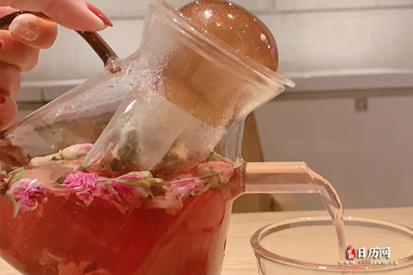 手拿玫瑰花茶茶壶