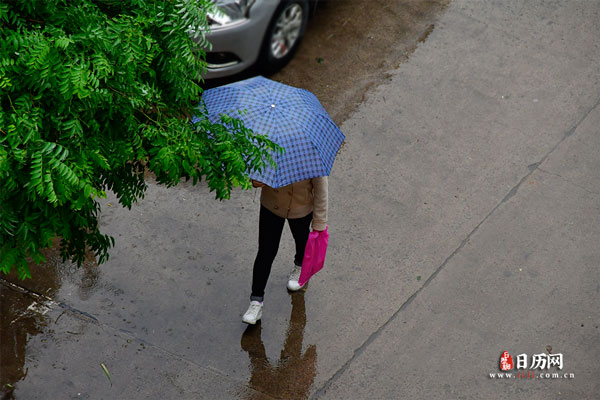 下雨天行人撑伞在街上走路