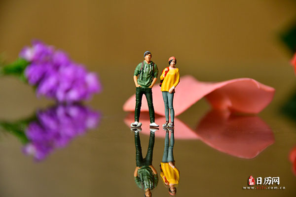情人节微缩摄影之情侣站在玫瑰花瓣前聊天